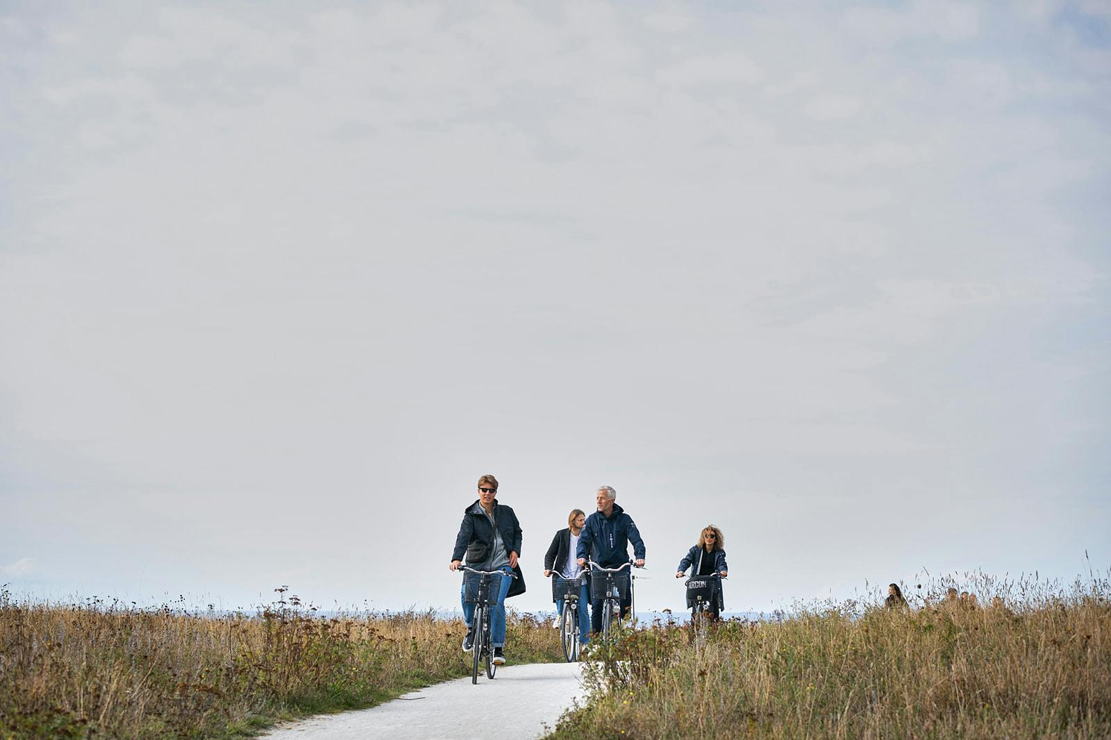 A group of people riding their bikes through a field